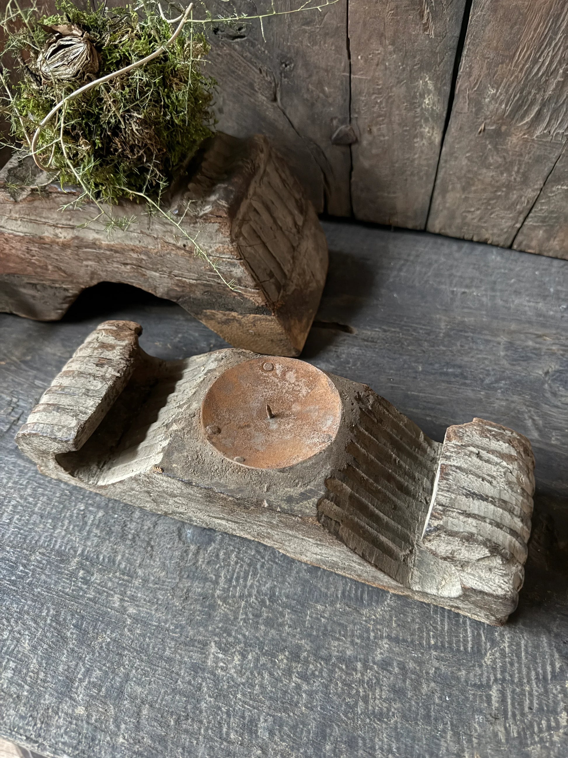 Authentieke houten ornament kandelaar op een verweerde houten tafel, landelijk sober interieur