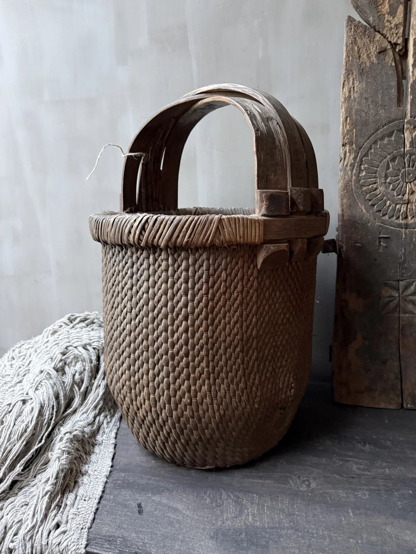 Authentieke handgemaakte rieten plukmand met houten hengsel, landelijk en sober interieur