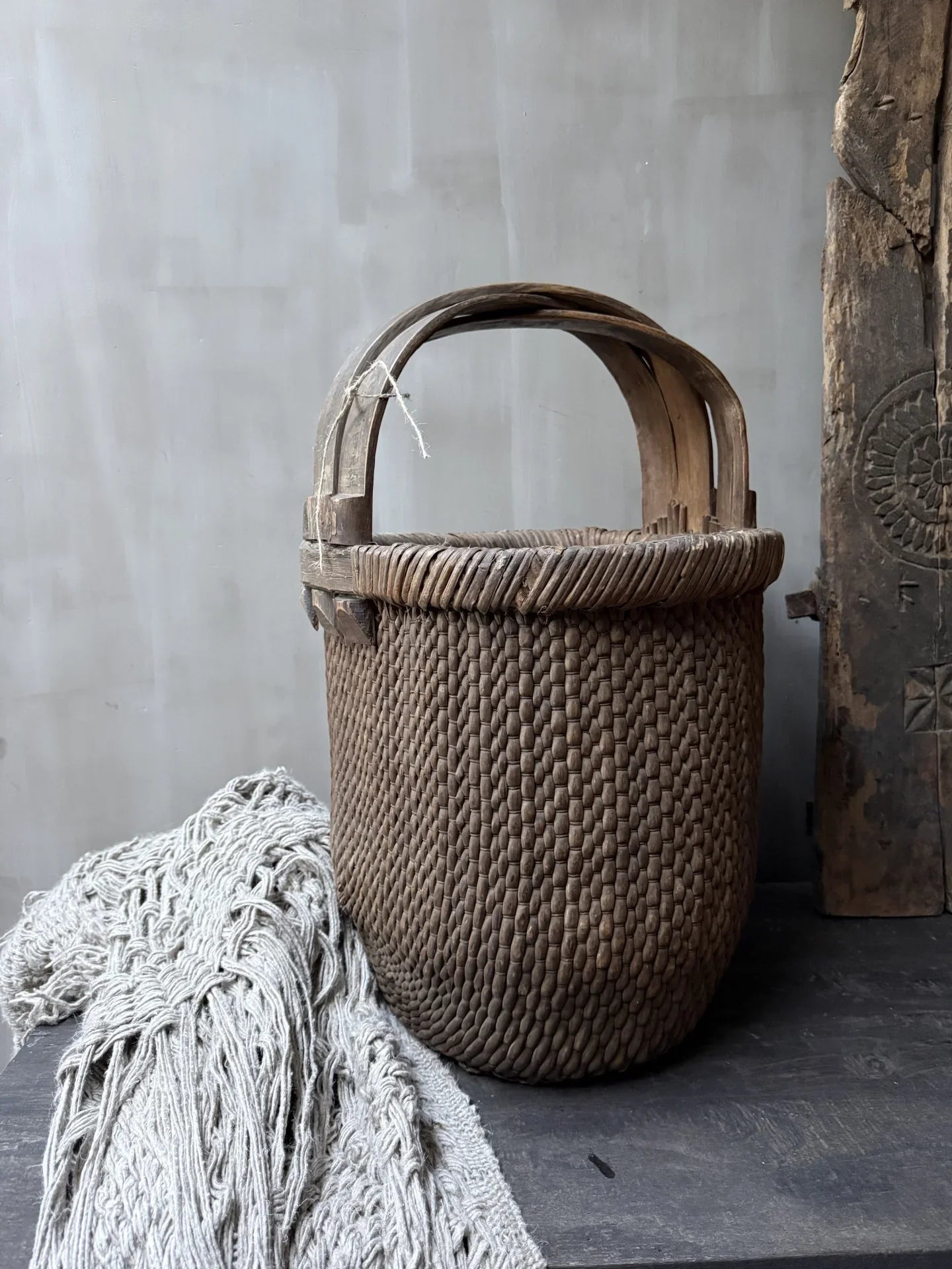 Authentieke handgemaakte plukmand van riet met houten handvat, landelijk en sober interieur