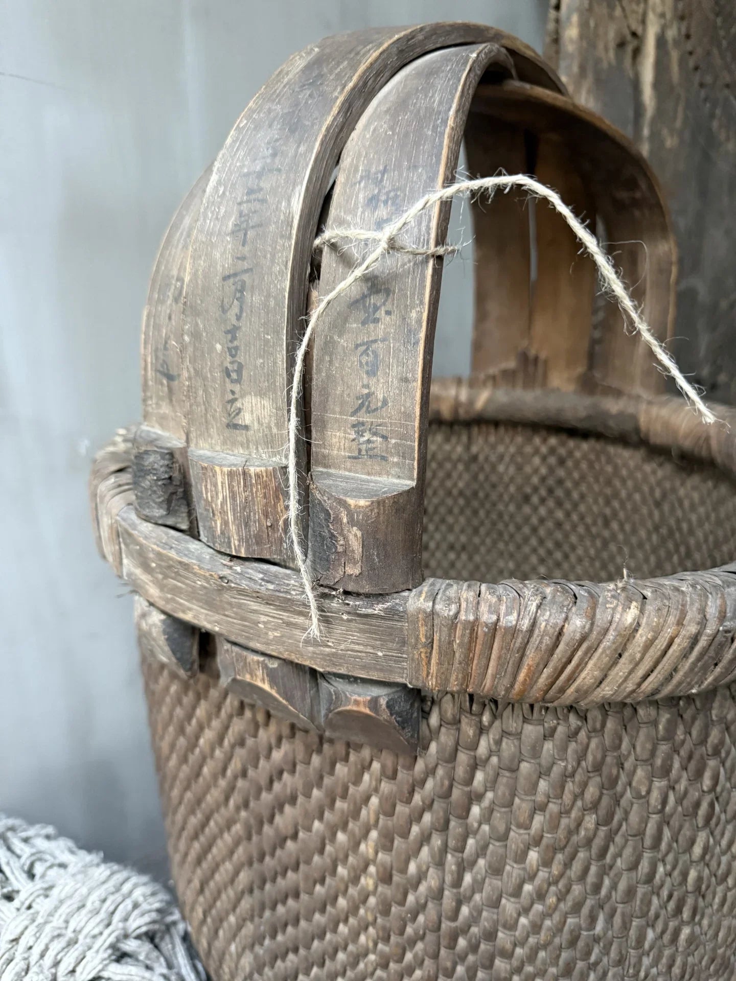 Authentieke handgemaakte plukmand met houten handvat en gevlochten patroon, landelijk interieur