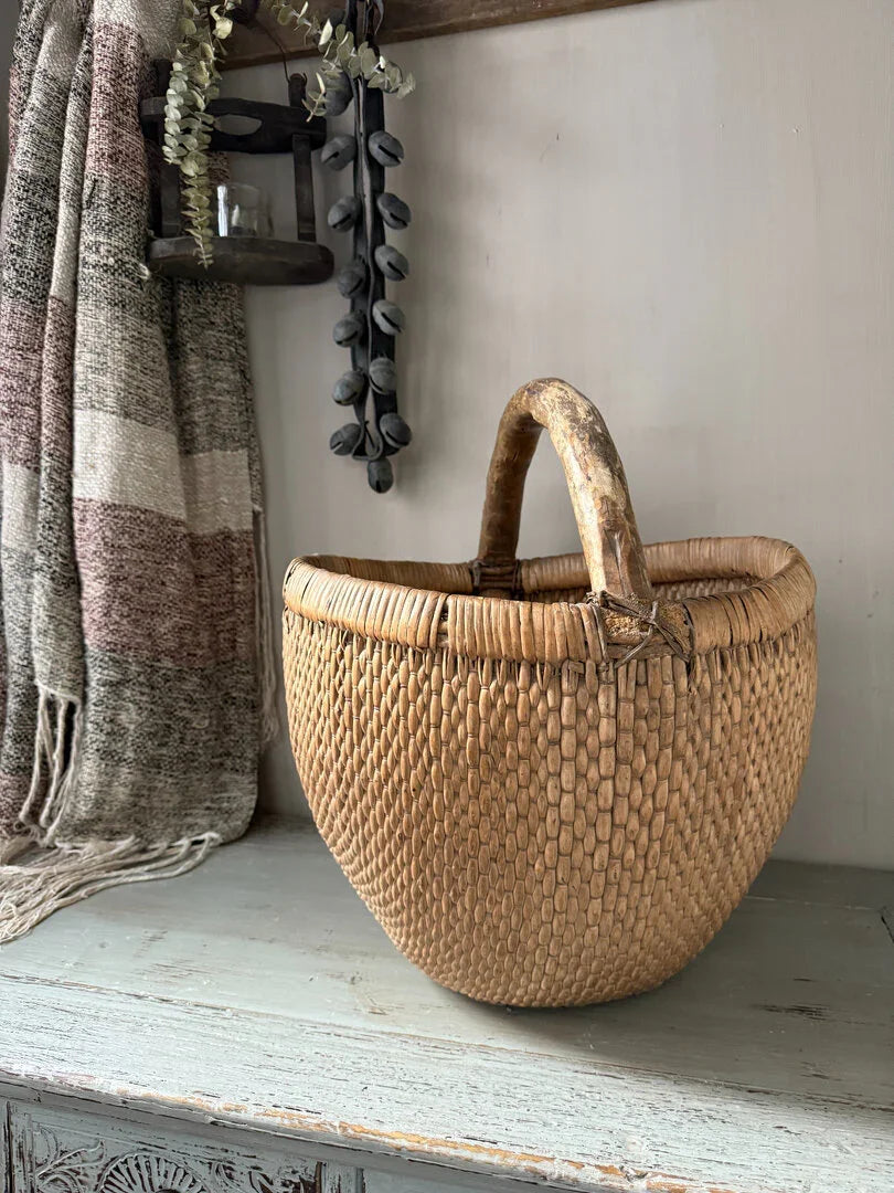 Handgemaakte plukmand van rotan op houten tafel, landelijk en sober interieuraccessoire