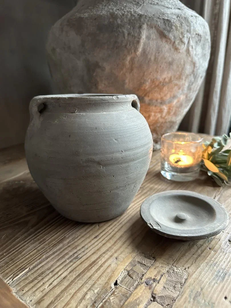 Handgemaakt sober grijs potje met deksel op houten tafel, landelijke woonaccessoire