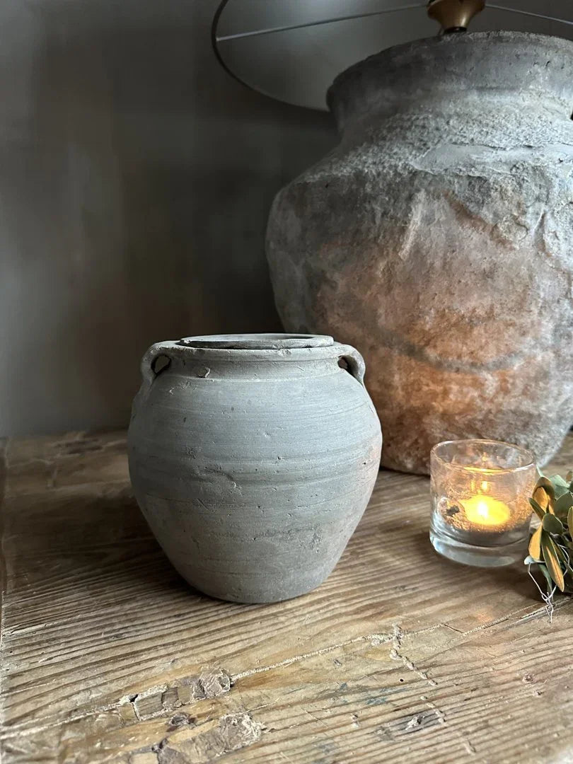 Authentiek, handgemaakt grijs potje met deksel op houten tafel, landelijk en sober interieur