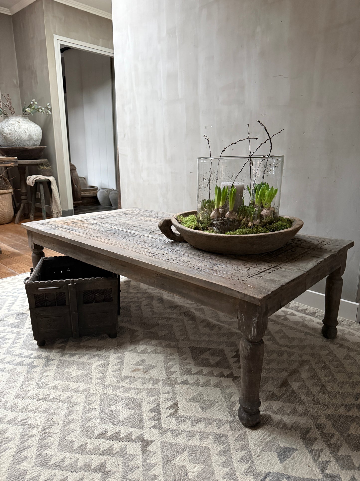 Handgemaakte houten salontafel met landelijke planten decoratie in sober interieur