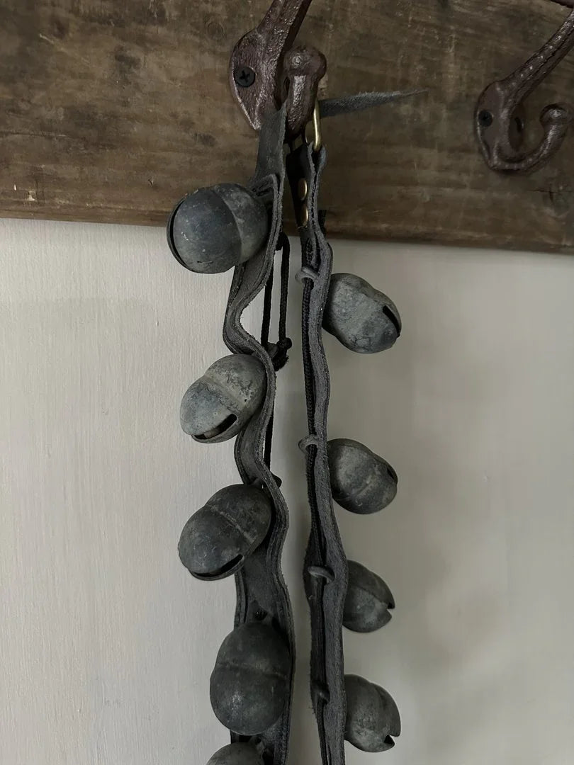 Authentieke handgemaakte schapenbel aan leren band, landelijke sobere woondecoratie aan kapstok.