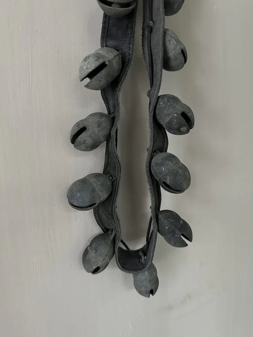 Handgemaakte landelijke schapenbel aan leren band, sober industrieel woonaccessoire