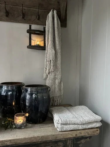 Shabby linnen doek op landelijke houten tafel, met zwarte potten en sfeervol kaarslicht, My Sober Home woonaccessoire.