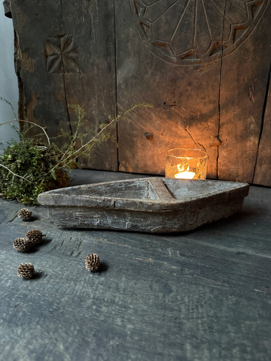 Handgemaakte houten schaal met waxinelichtje en natuurlijke decoratie, sober landelijk interieur