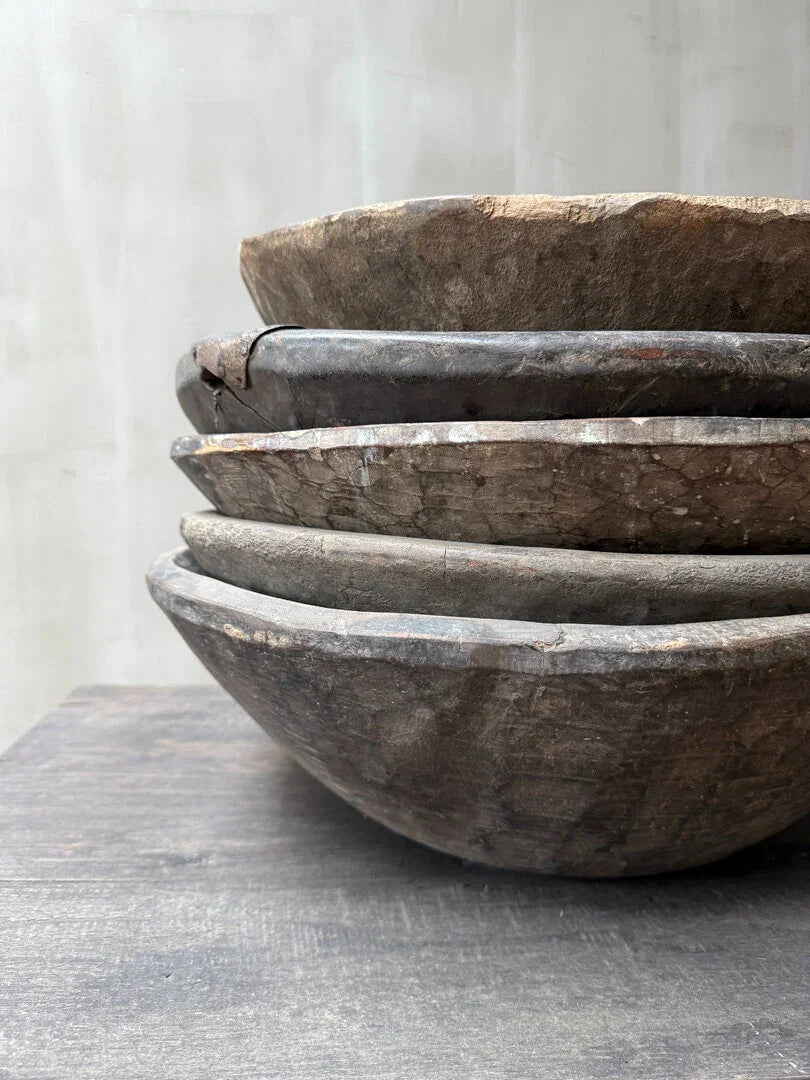 Stapeltje authentieke, handgemaakte houten schalen op tafel, sober landelijk interieur