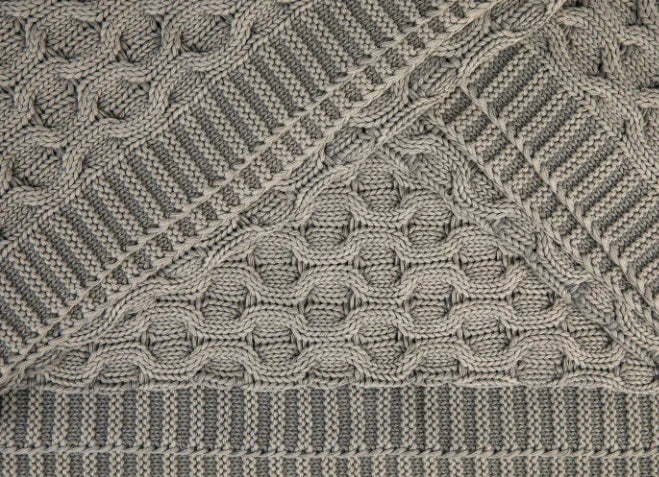 Close-up van grijs, handgebreid plaid met uniek patroon voor sober interieur bij My Sober Home