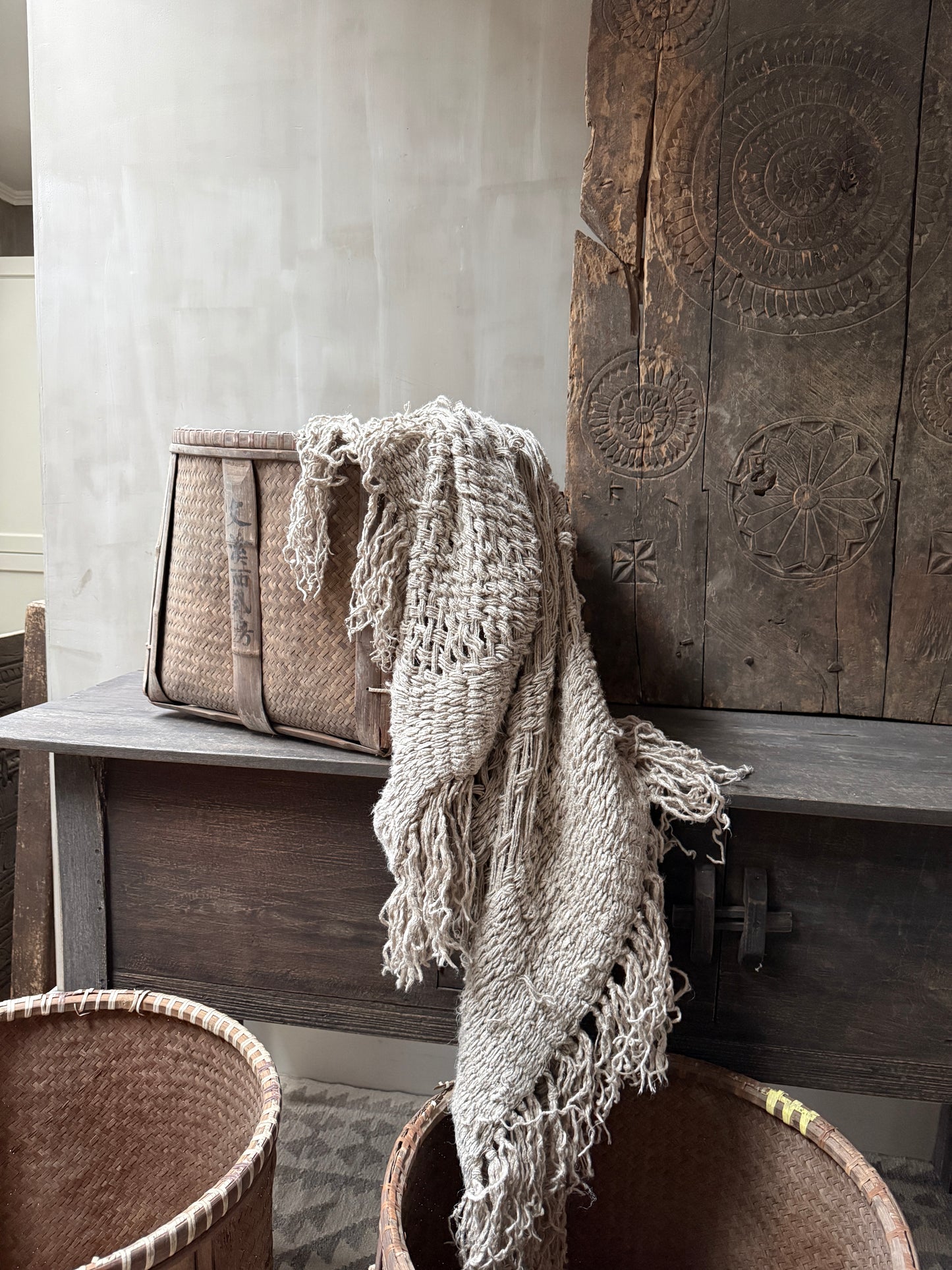 Handgemaakte rieten mand met grof gebreide beige plaid, sobere landelijke woondecoratie