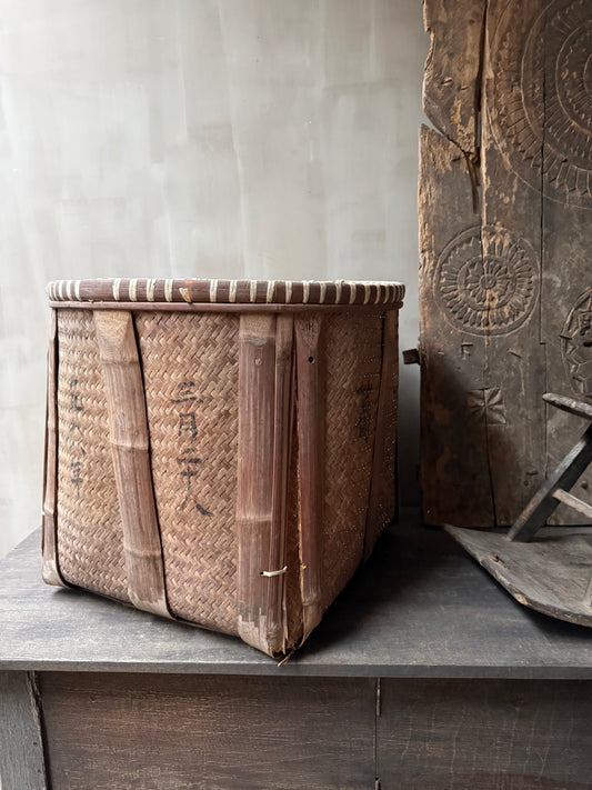 Handgemaande, sobere rieten mand uit India op houten tafel, landelijk interieuraccessoire