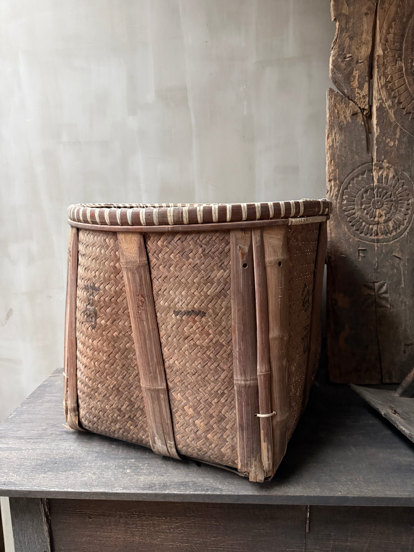 Authentieke handgemaakte rieten mand uit India, landelijke woonaccessoire op houten tafel.