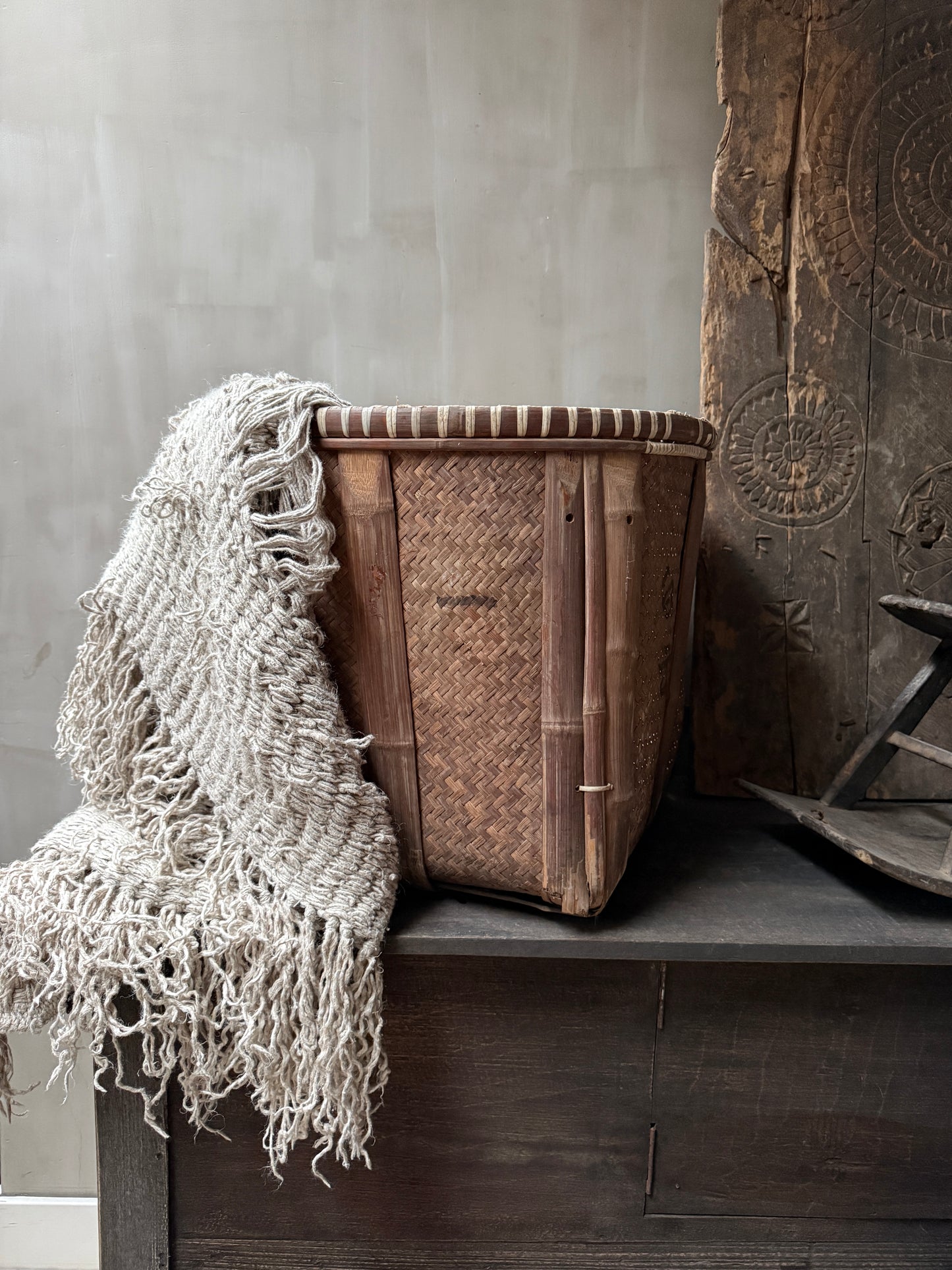 Handgemaakte rieten mand met grof gebreide plaid, landelijk sober interieuraccessoire