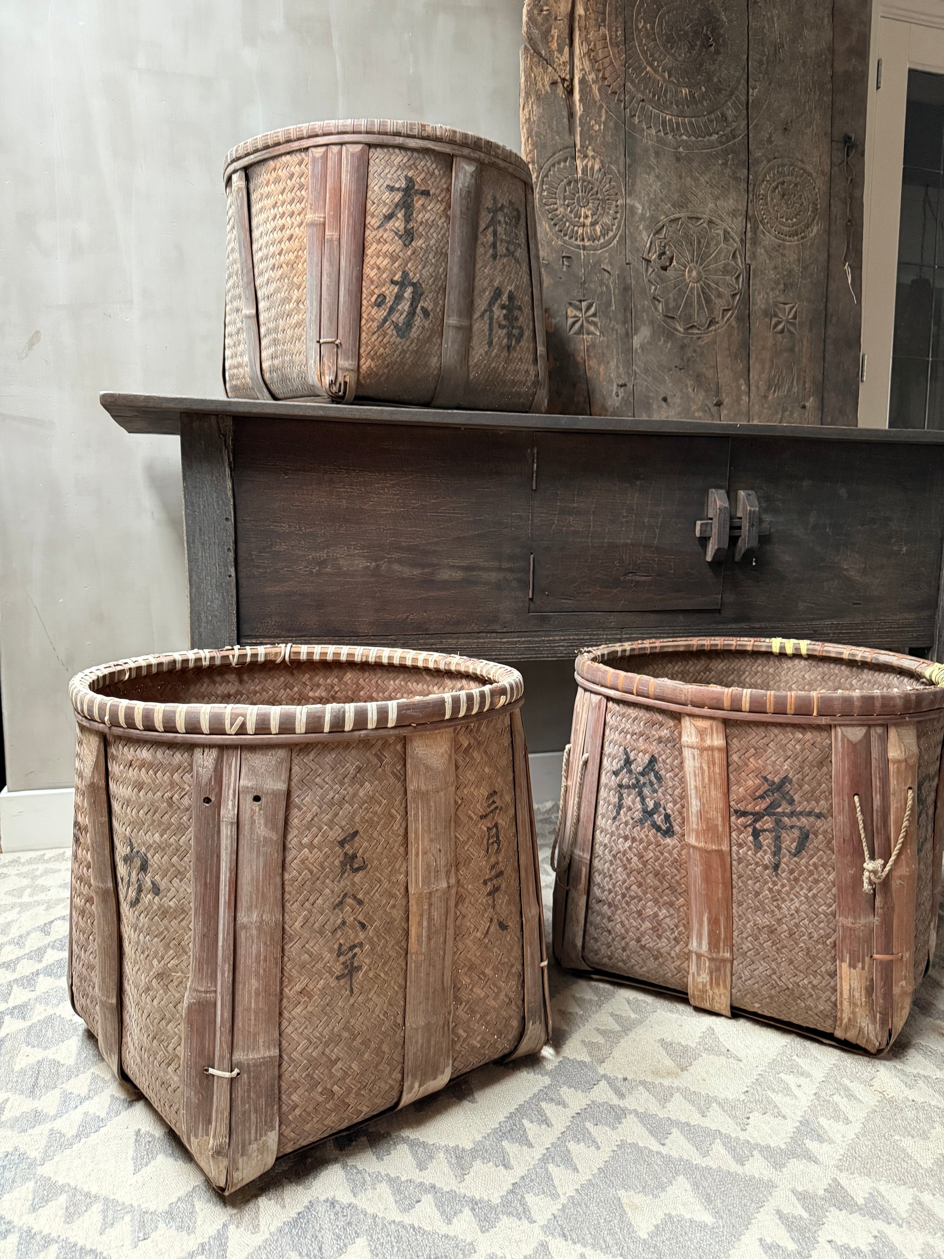 Authentieke handgemaakte rotan manden met Aziatische karakters in sober, landelijk interieur