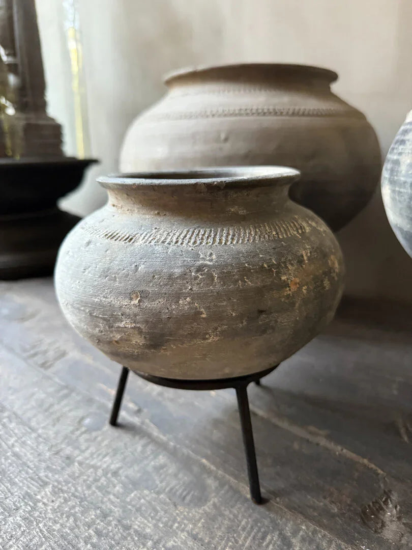 Authentieke handgemaakte vintage tuimelkruik op metalen standaard, sober landelijk interieur