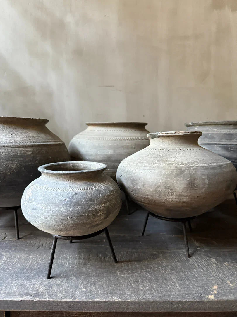 Handgemaakte grijze tuimelkruiken op metalen standaards, landelijke woonaccessoires