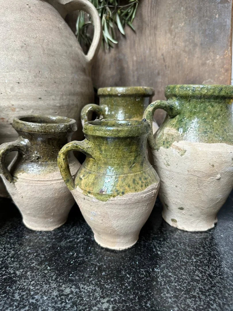 Authentieke, handgemaakte Turkse kruikjes met groene glazuur op zwarte tafel, landelijk interieur