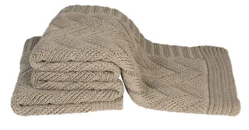 Handgemaakte beige gebreide plaid met visgraatpatroon, sober en landelijk woonaccessoire