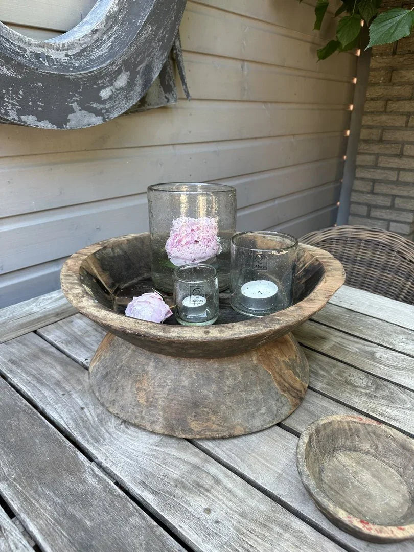 Oude houten vijzel schaal met glazen windlichten en roze bloem, landelijke decoratie op houten tafel