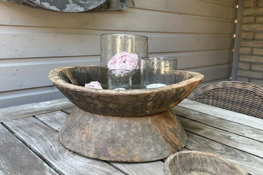 Handgemaakte houten vijzel schaal met glazen windlichten en roze bloemen op een landelijke houten tafel, sober interieurdecor My Sober Home.
