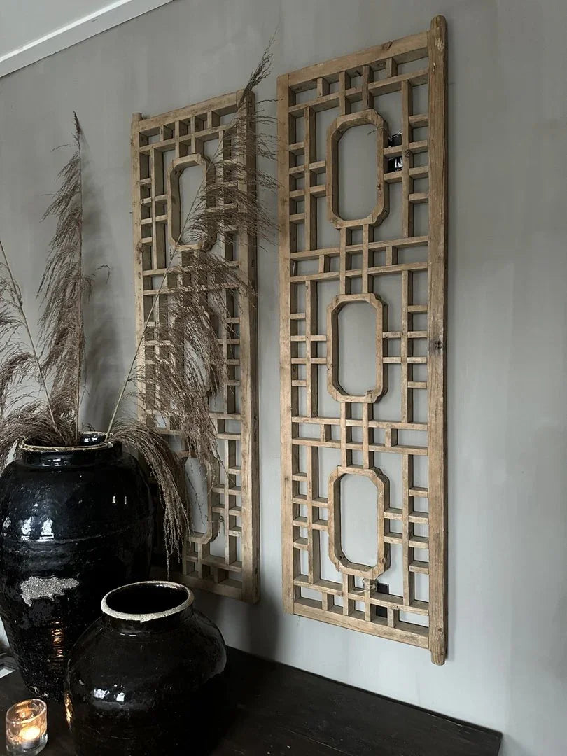 Handgemaakt houten wandpaneel en zwarte aardewerken potten in sober landelijk interieur