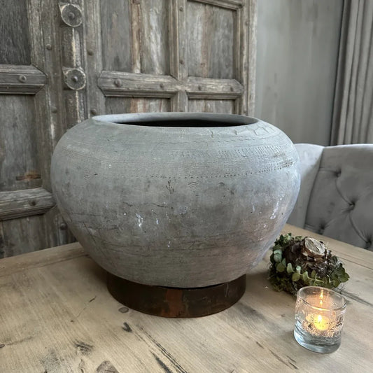 Authentieke, handgemaakte sobere grijze pot op houten tafel in landelijke woonkamer