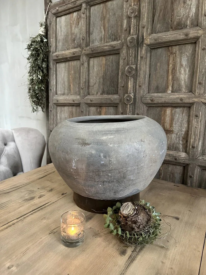 Handgemaakte Wankelpot ring van grijs aardewerk op houten tafel, landelijke sobere woonstijl