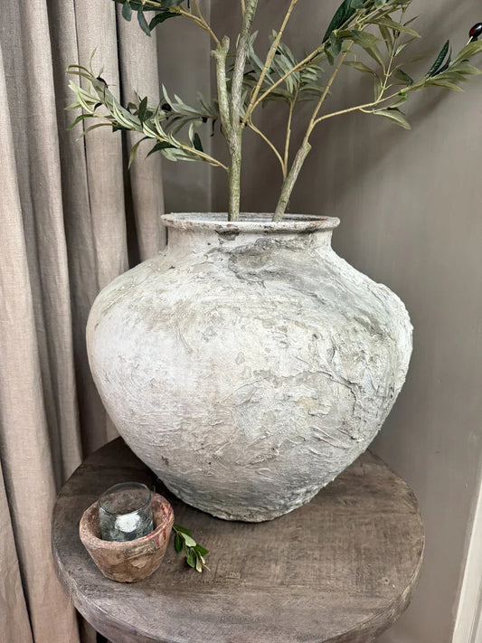 Grote landelijke waterkruik met takken op houten tafel, sobere woonaccessoire My Sober Home