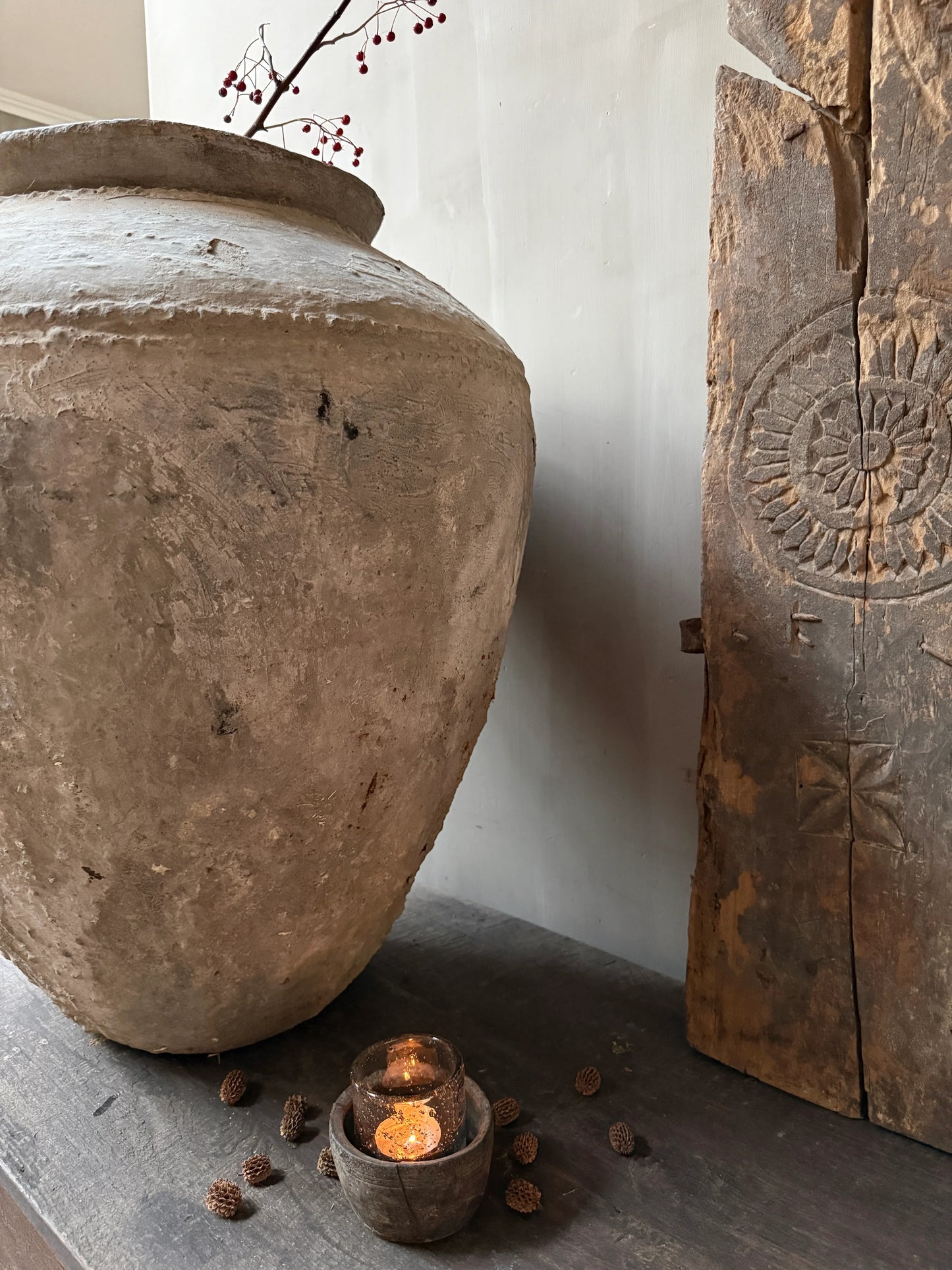 Authentieke handgemaakte waterpot met tak, houten ornament en kaars op landelijke tafel, My Sober Home