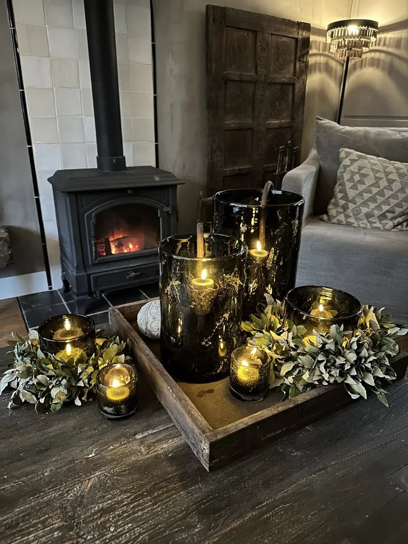 Waxinelichtjes in zwart glas op houten dienblad, sfeervol landelijk interieur met open haard, My Sober Home.