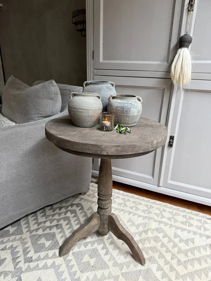 Houten wijntafel met drie grijze potten en kaarsje, sfeervol landelijk interieur