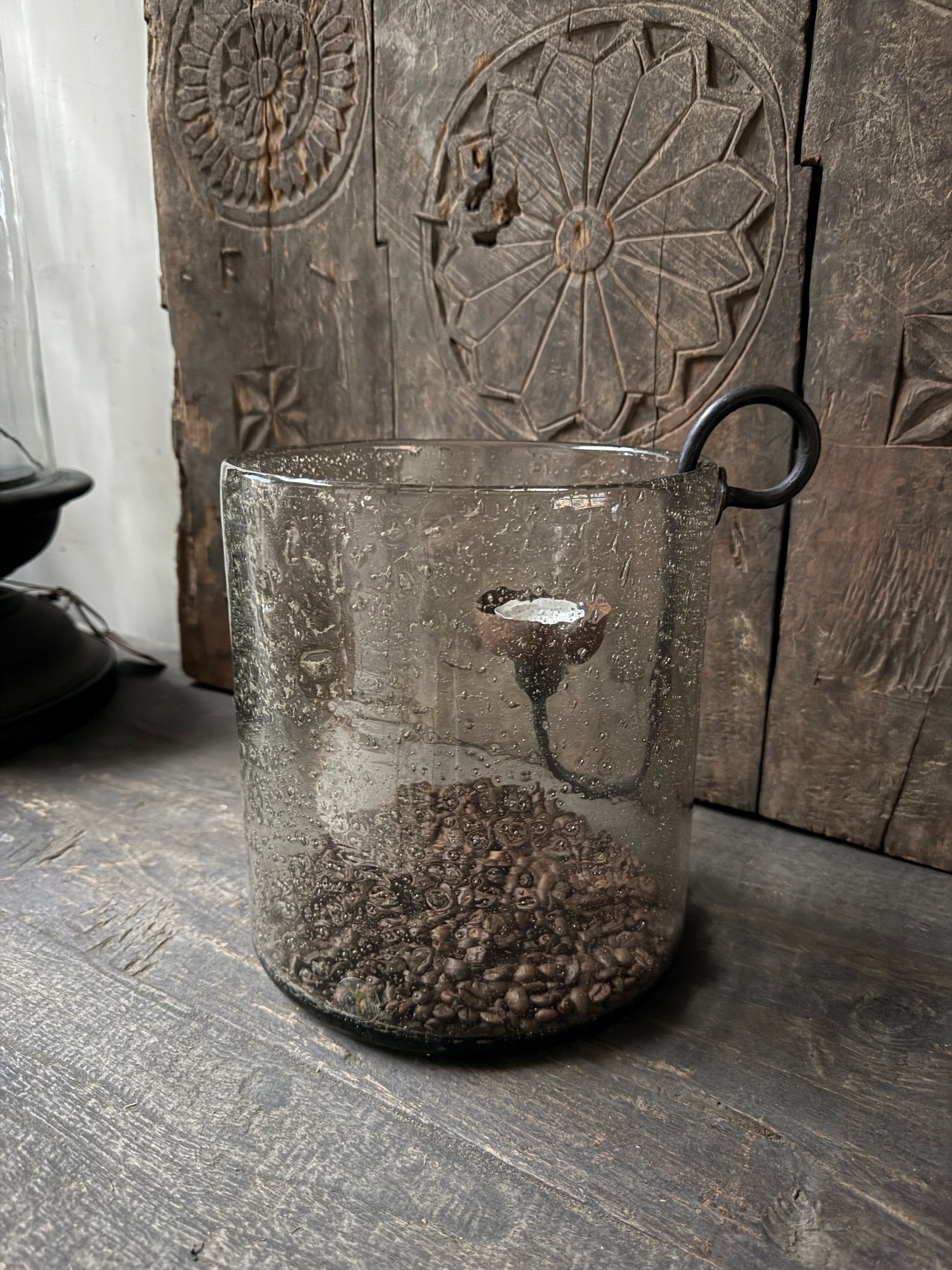 Handgemaakt windlicht met koffiebonen op houten tafel, sober landelijk interieur