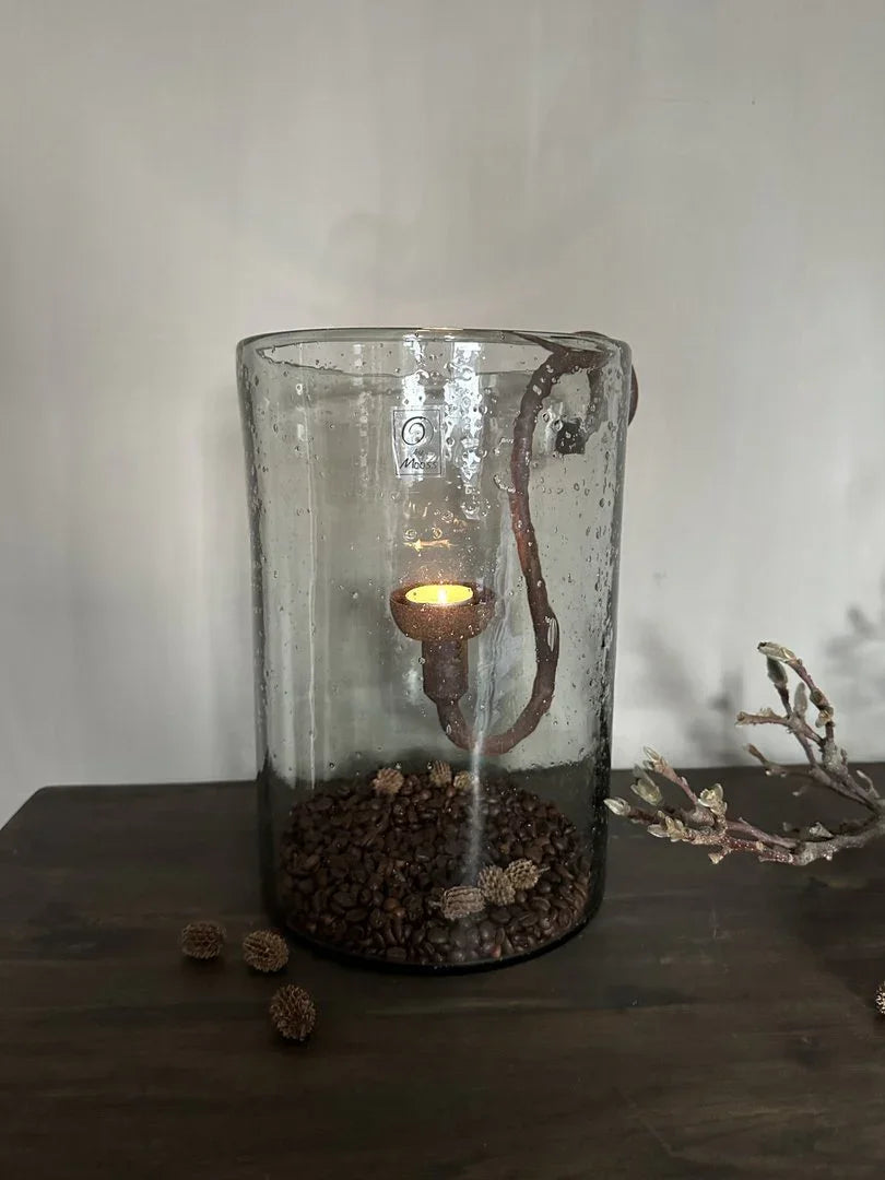 Handgemaakt windlicht van glas met steenslag, gevuld met koffiebonen, sfeervol op houten tafel