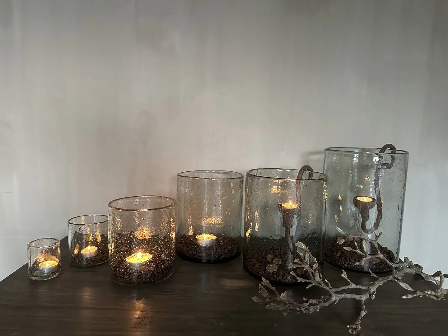 Handgemaakte windlichten met rustieke kaarsen op houten tafel, landelijk sober interieur