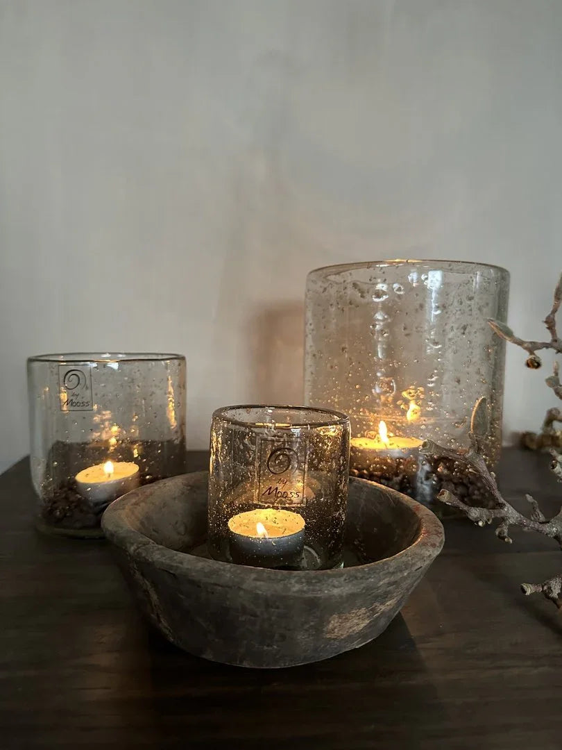 Set van drie windlichten steenslag met kaarsen, sfeervol op houten tafel in sober interieur.