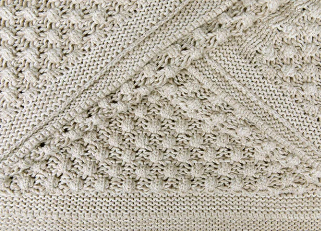 Close-up van beige woondeken, grof gebreid, handgemaakt, My Sober Home woonaccessoire.