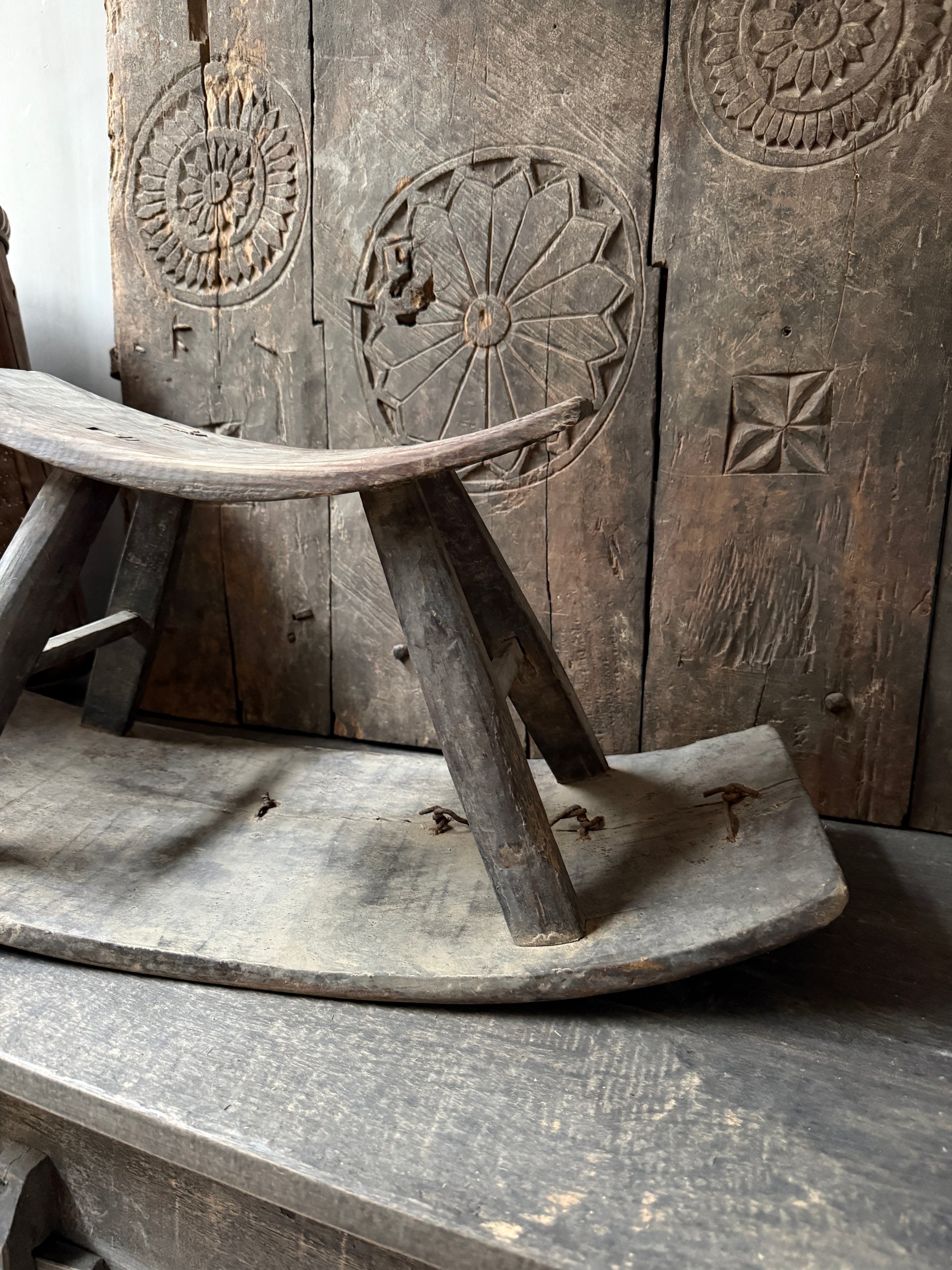 Authentiek handgemaakt houten zaaikrukje met houtsnijwerk, sober landelijk interieur