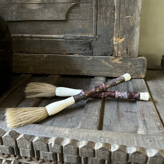 Authentieke kalligrafeerkwast met houten handvat en wit detail op een sobere houten tafel, My Sober Home