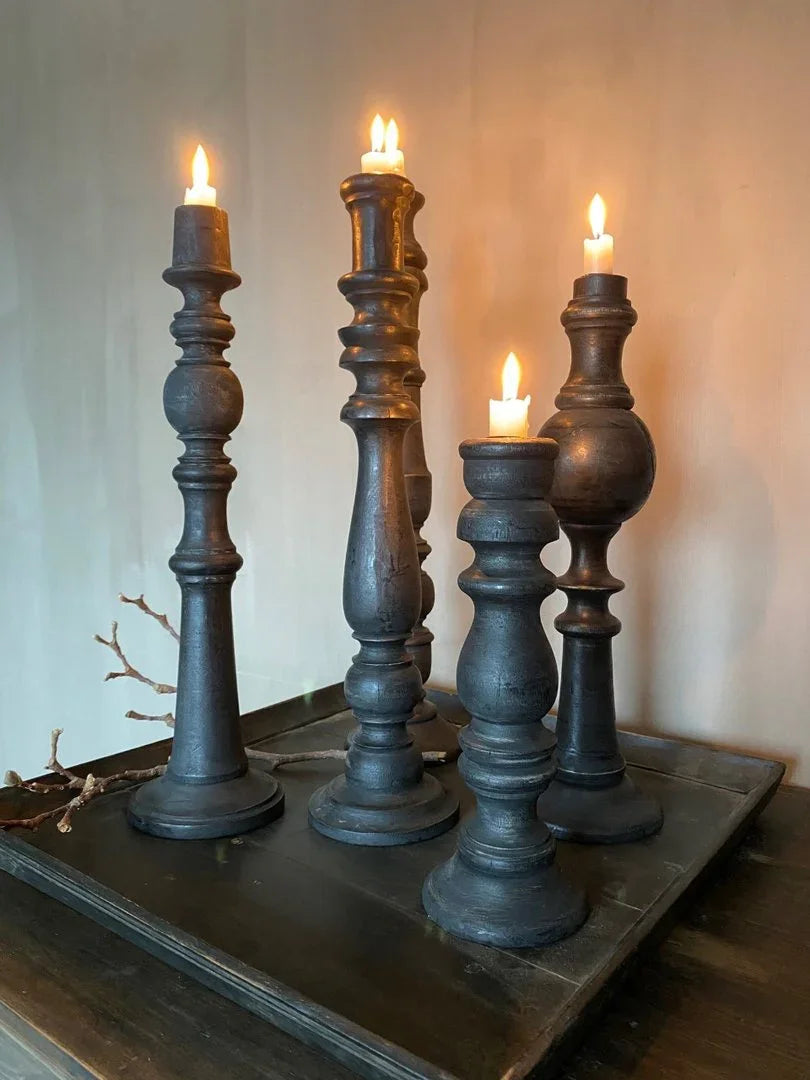 Handgemaakte zwarte kandelaars met brandende kaarsen op houten dienblad, landelijk interieur